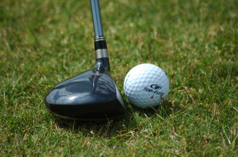 Fairway wood positioned near golf ball