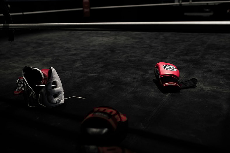 red boxing gloves and helmet on black floor